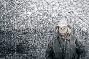 Standing in a Blizzard on Her Colorado Ranch, a Woman Poses in her Work Coat for Director/Photographer Tyler Stableford.