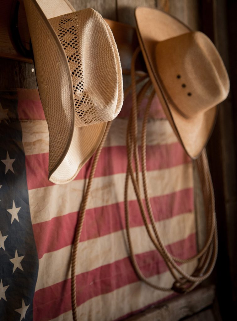Cowboy Hats Hang By American Flag