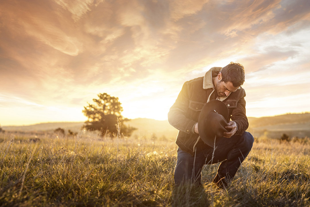 Iconic Cowboy In Field At Sunset