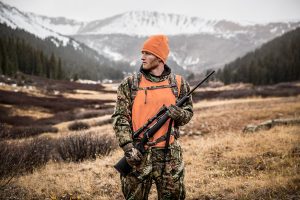 Rifle in Hand, this Big Game Hunter Poses in Front of Snow-capped Mountains. Portraits like this One Highlight the Rugged Nature of Hunting.