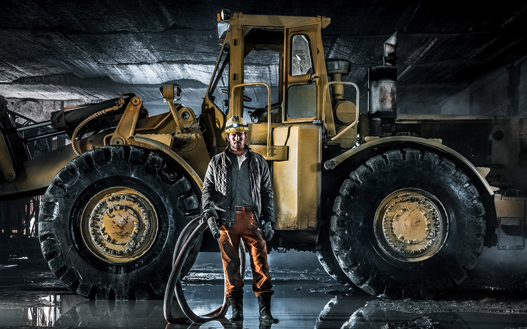 Quarry Worker In Mine Standing In Front Of A Frontloader For Walls Workwear, Dickeys Clothing, Cabelas, Timberland