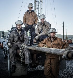 Four Oil and Gas Miners Pose in Work Wear Near their Well-pad in Colorado. All Four Wear Clothing and Footwear Meant for Heavy Industry.