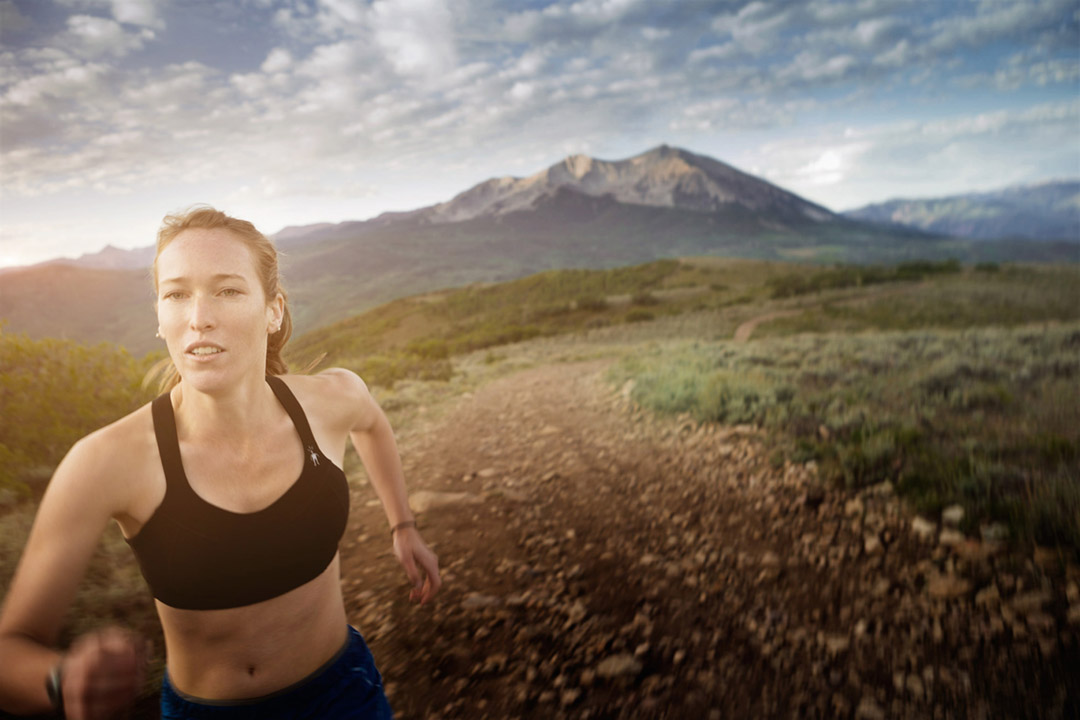 This photo of a Female Long-Distance Runner Shows Rugged Terrain of the Rocky Mountians in the Backdrop. Exercising in the Outdoors is Part of the Colorado Lifestyle.