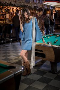 Leaning on a Pool Table in a Western Style Bar, this Woman in Cowboy Boots and Casual Western Apparel Highlights a Friday Night in American West.