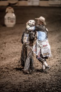 This Young Cowboy Finds Support from a Professional Rodeo Clown After a Hard Fall While Bull-Riding. This is a Rare Image of Camaraderie in an Extremely Dangerous Sport.