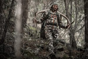 a hunter carrying a rack after field dressing an elk on a big game alpine hunt.