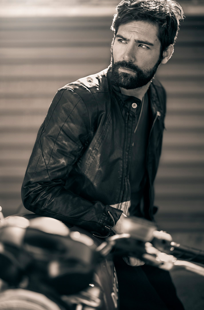 Sexy man on motorcycle with vintage leather jacket.