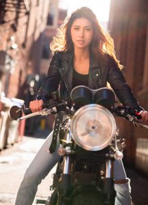attractive woman on motorcycle wearing vintage leather jacket on the streets of Denver.