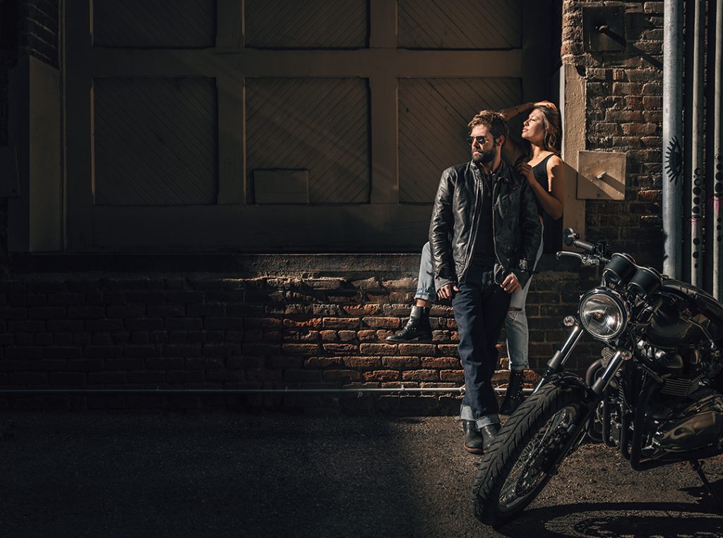 Young urban couple with vintage motorcycle in Denver Colorado.