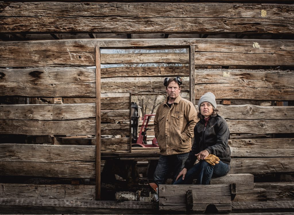A man and woman take a break from working at a reclaimed timber mill which supplies wood products to Patagonia retail.